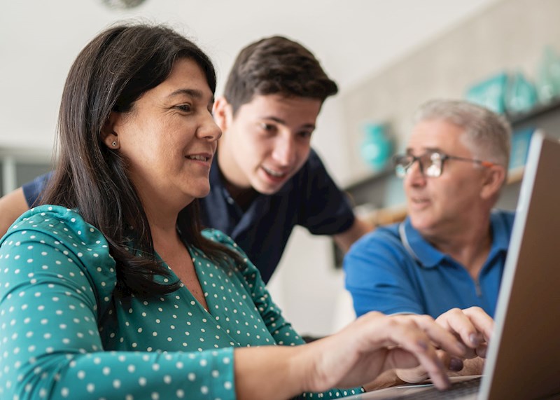 Parents and their son looking at a laptop